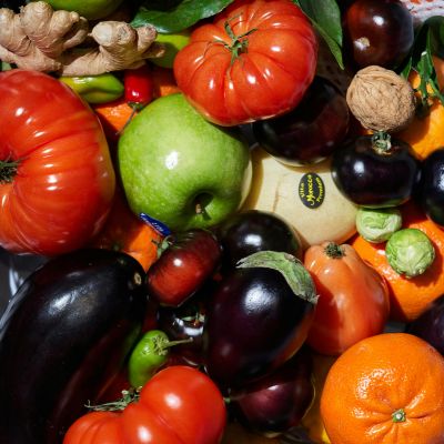 A diverse assortment of fruits and vegetables rich in vitamins, including apples, oranges, tomatoes, peppers, and broccoli
